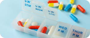 Plastic containers with pills on blue background