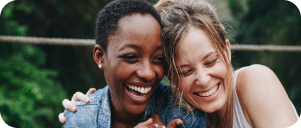 Two girl friends laughing and embracing each other