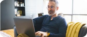 Image of man sitting on a sofa on his laptop